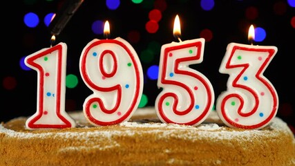 Birthday cake with white burning candles in the form of number 1953