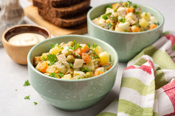 Traditional Russian salad Olivier in bowls on concrete background