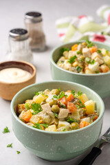 Traditional Russian salad Olivier in bowls on concrete background
