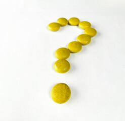 horizontal question mark with yellow wooden balls on white paper