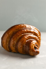 Freshly backed french croissant with chocolate filling lies on the table. Delicious French pastries. Copy space. Close-up. Selective focus. Vertical orientation.