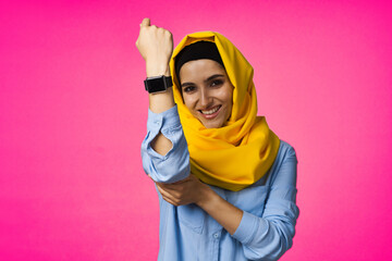 muslim woman with smart watch technology posing pink background