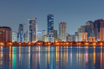 Fototapeta premium The tallest towers in the Emirates and their reflection on the lakes at night, Dubai, Sharjah