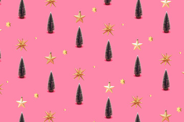 Pattern made of Christmas tree, gold star, shiny ornament on bright pink background. Minimal flat lay concept.