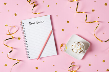 Letter to Dear Santa. Pink pen decorated with feather and Notepad isolated on pink background with...