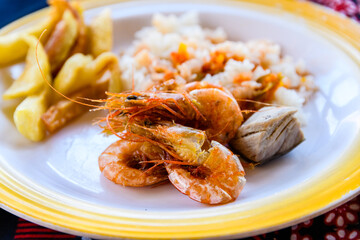 Prepared shrimps and pieces of barracuda fish on a plate