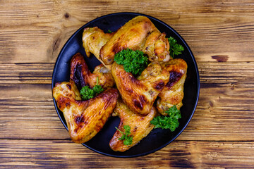 Pile of the roasted chicken wings on plate. Top view
