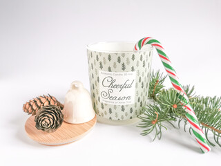 Obraz na płótnie Canvas Cozy moments with aromatic candle, bell, pine cones and christmas tree on a white background.
