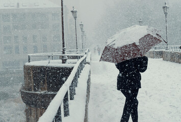 Mujer joven divertida bajo una tormenta de nieve