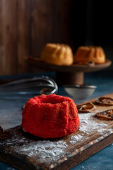 mini red velvet puddings with vanilla puddings with icing sugar whisk and lemon slices dark food...