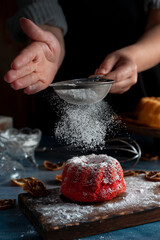 mini red velvet puddings with vanilla puddings with icing sugar whisk and lemon slices dark food style