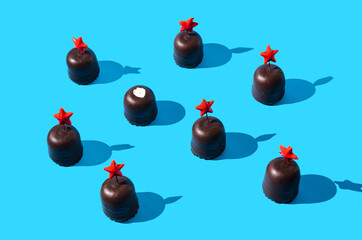 Chocolate cones with red stars on top, one without. Blue background. Cute surreal Christmas or New Year creative concept for web banner or advertisement.