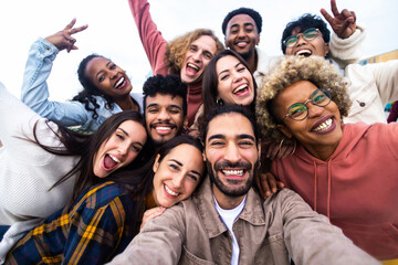 Big group portrait of diverse young people together outdoors - Multiracial happy millennial male and female friends having fun together - Unity and friendship concept - Focus on man in the center - Powered by Adobe