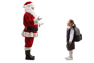 Surprised girl in a school uniform looking at santa claus