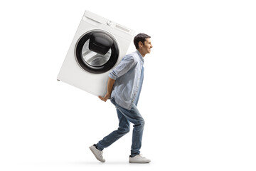 Full length profile shot of a casual young man carrying a washing machine on his back