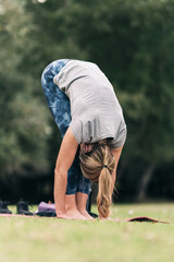 Woman stretching her back while doing yoga outdoors
