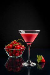 drink in glass and glass of milk cocktail and strawberries forming a splash with natural strawberries in a bowl