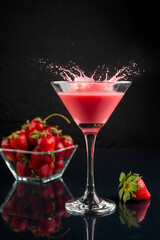 drink in glass and glass of milk cocktail and strawberries forming a splash with natural strawberries in a bowl