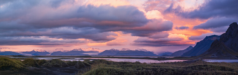 Fototapeta premium Sunrise Stokksnes cape sea beach, Iceland. Amazing nature scenery, popular travel destination. Autumn grass on black volcanic sand dunes.