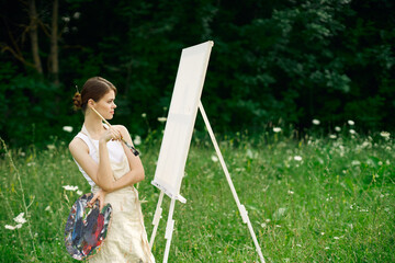woman artist with palette of paints drawing easel nature hobby