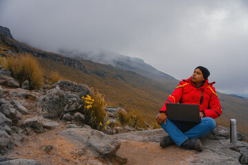 Naklejka premium Millennials freelancer works remotely on a trip to the mountains. Morning coffee at work on the computer. Concept of work on vacation