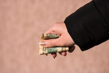 Hands giving money like a bribe or tips. Holding US dollars banknotes on a blurred background, US...