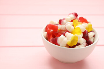 Delicious gummy ice cream cones shaped candies on pink wooden table. Space for text