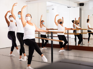 Fototapeta na wymiar Group of multiethnic dancers training in masks during COVID-19 pandemic