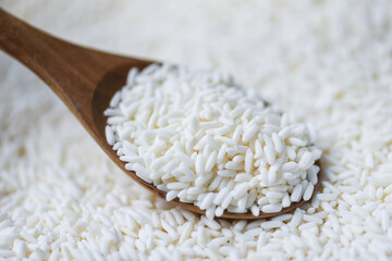 Jasmine white rice on wooden spoon in the the sack, harvest rice and food grains cooking concept