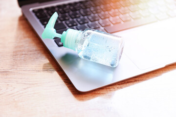 Disinfects the surface of the laptop by sanitizer spray or alcohol gel washing hand hygiene on the...