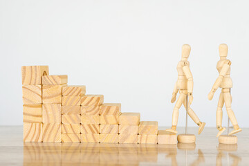 A wooden staircase and two wooden puppets are walking up. Steps to grow a business to success or a...