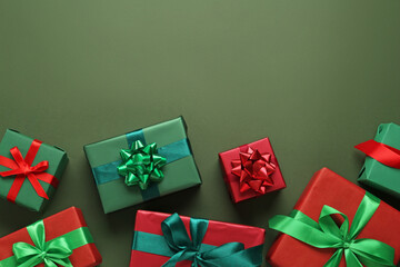 Many gift boxes on dark green background, flat lay. Space for text
