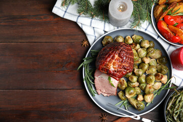 Festive flat lay composition with delicious ham on wooden table, space for text. Christmas dinner