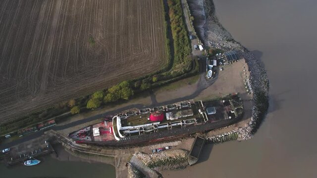 Passenger vessel moored on sandy coast, aerial fast ascend shot