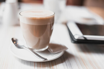 Cup with cappuccino and milk foam on the table in a cafe