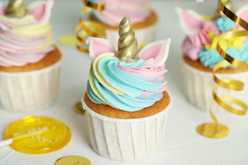 Cute sweet unicorn cupcake on white table. Festive treat