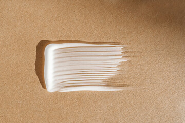 White cream texture on a beige background.