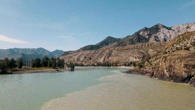 Two rivers collide into one with amazing mountain view. Drone footage