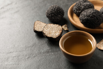 Bowl of truffle oil on grey table. Space for text
