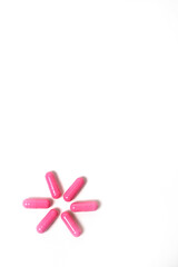 розовые таблетки на белом фоне