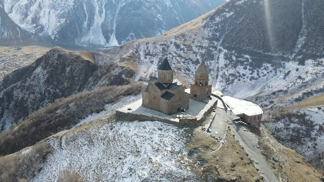 Gergeti Trinity church in Stepantsminda with majestic mountains Kazbegi in the background, Georgia. Epic religious and historical monument of architecture in Caucasus mountains in Georgia