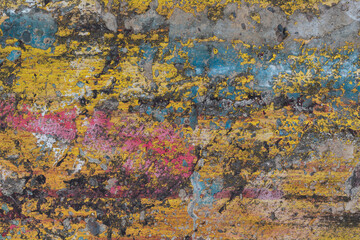 Old concrete wall with multicolor paints. Peeling textured surface.