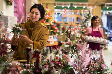 Asian woman choosing christmas gifts on sale in store