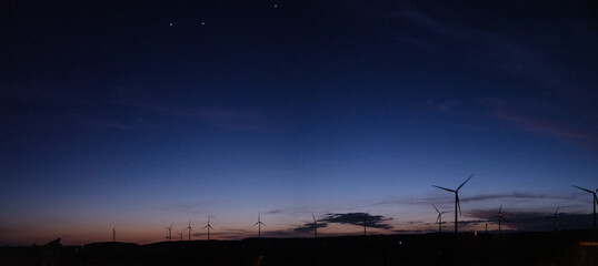 Fototapeta na wymiar Wind turbines in night time landscape