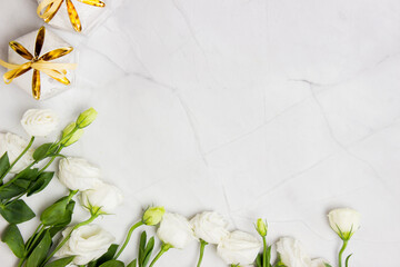 White roses with golden boxes over the white marble background.