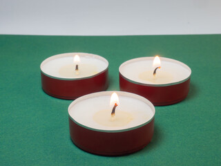 Flat candles on the table. Small candles on a green background.