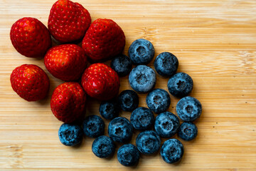 Strawberries and blueberries on a wooden borad