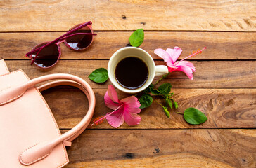 hot coffee, sunglasses and pink hand bag of lifestyle woman relax arrangement flat lay style on background wooden