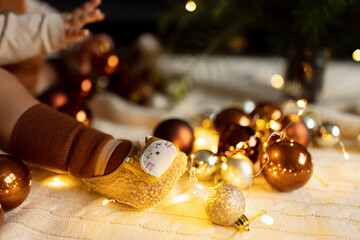 Lifestyle portrait of cute caucasian baby one year old playing with baubles on floor at home. Merry Christmas xmas and happy new year 2022