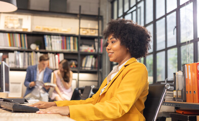 Young African American female architect working in an office.Portrait of a confident black businesswoman with all african american team in working room.